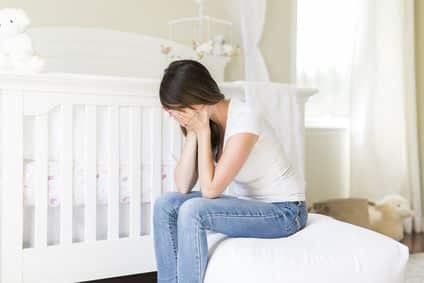 Depressed young woman in baby room